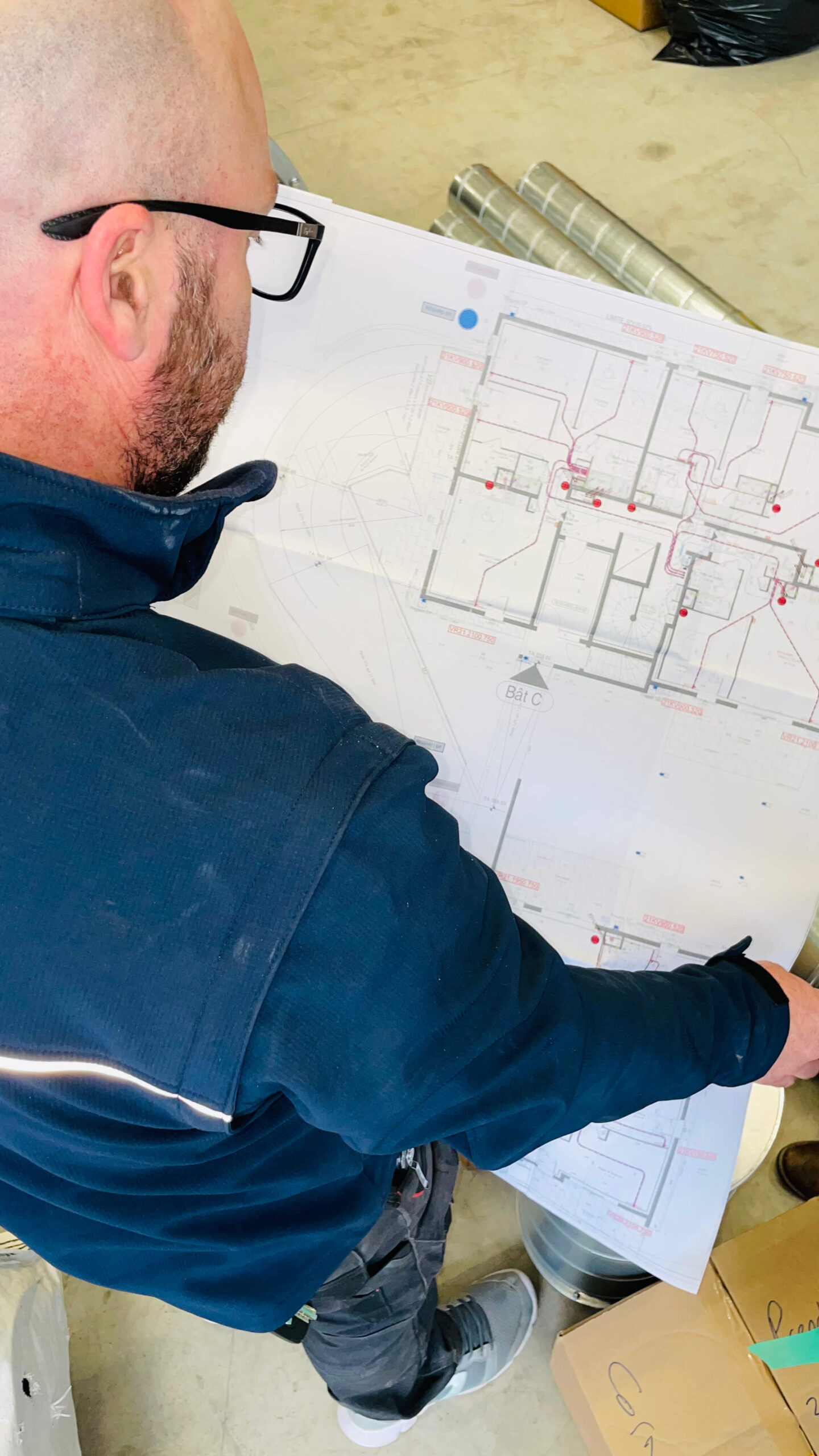 Technicien Métalp lisant les plans d'exécution d'un bâtiment