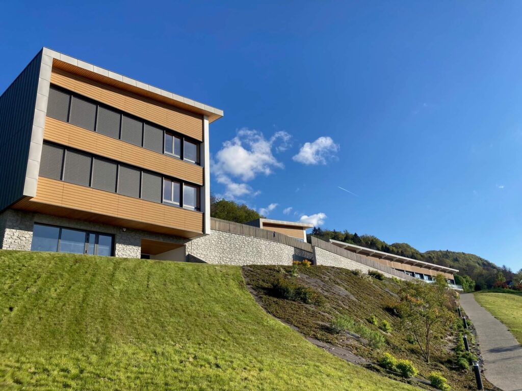 École aérospatiale — bâtiment public à ossature bois adossé à la montagne